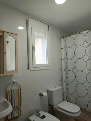a bathroom with a toilet and a sink and a window at Casa con piscina Sant Pol de Mar in San Pol de Mar