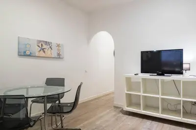 a living room with a table and a tv on a cabinet at Bebarceloner Poble Nou Apartaments - 2 bedroom in Barcelona