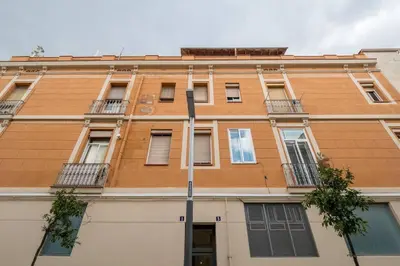 a tall orange building with windows and a street sign at Bebarceloner Poble Nou Apartaments - 2 bedroom in Barcelona