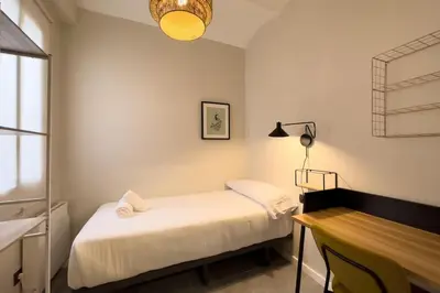 a small bedroom with a bed and a desk at BeBarceloner Sants Apartments - 2 bedrooms in Barcelona