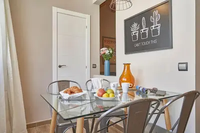 a glass table with chairs and a bowl of fruit on it at BeBarceloner Sants Apartments - 2 bedrooms in Barcelona