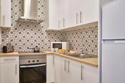 a kitchen with white cabinets and a sink and a microwave at BeBarceloner Sants Apartments - 2 bedrooms in Barcelona