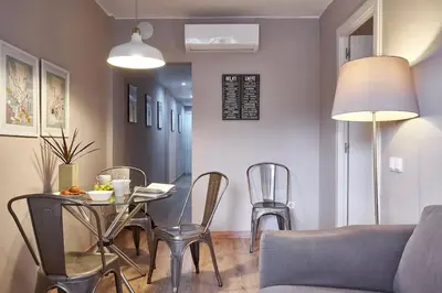 a living room with a table and chairs and a couch at BeBarceloner Sant Andreu Apartments - 3 bedrooms in Barcelona