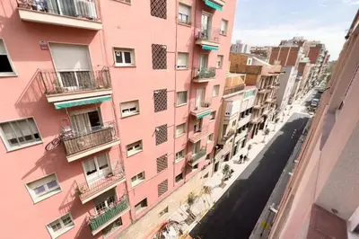 a pink building with balconies on a city street at BeBarceloner Sant Andreu Apartments - 3 bedrooms in Barcelona