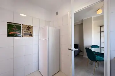 a white refrigerator in a room with a table at BeBarceloner Sant Andreu Apartments - 3 bedrooms in Barcelona