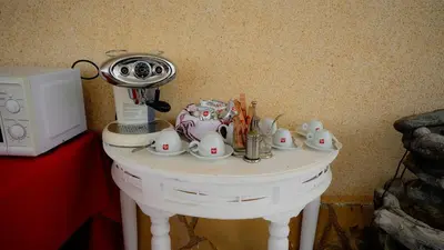 a table with cups and dishes on it next to a microwave at La Casa de Mima in Cubelles