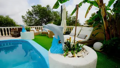 a swimming pool with a dolphin planter in a yard at La Casa de Mima in Cubelles