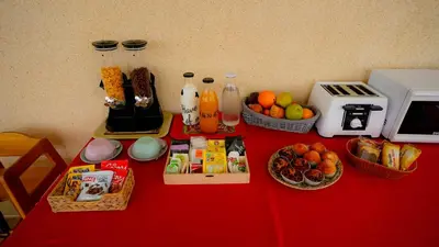 a red table with food and drinks and baskets of fruit at La Casa de Mima in Cubelles