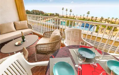 a balcony with tables and chairs and a view of the beach at Nice Apartment In Pineda De Mar in Pineda de Mar