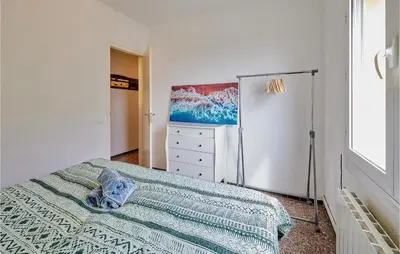 a bedroom with a bed and a dresser in it at Nice Apartment In Pineda De Mar in Pineda de Mar