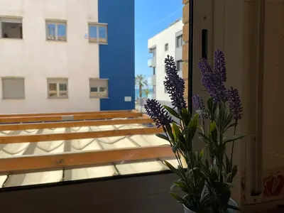 a vase of purple flowers sitting in a window at Cozy Beach House with Pool & BBQ in Cubelles