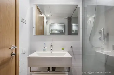 a white bathroom with a sink and a mirror at Flateli Navas A01 in Barcelona