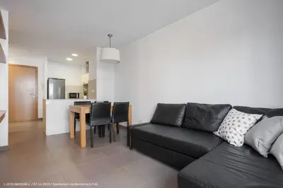 a living room with a black couch and a table at Flateli Navas A01 in Barcelona