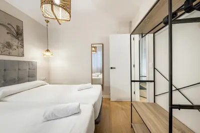 a bedroom with two beds and a glass wall at BeBarceloner Eixample Apartments in Barcelona