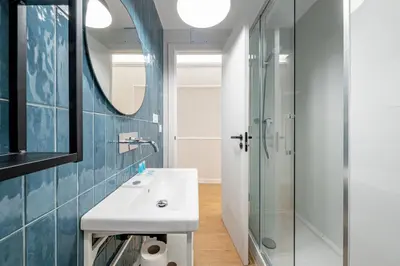 a bathroom with a sink and a glass shower at BeBarceloner Eixample Apartments in Barcelona