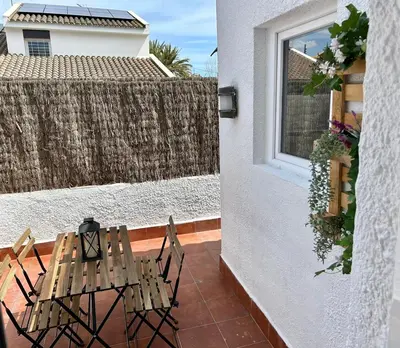 a patio with two chairs and a table and a window at Vilamarlux VII in Vilassar de Mar