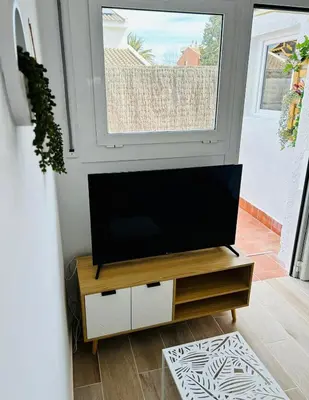 a flat screen tv sitting on a stand in a living room at Vilamarlux VII in Vilassar de Mar