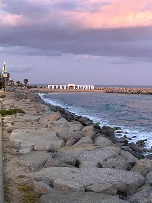 a group of rocks on a beach near the water at Vilamarlux VII in Vilassar de Mar