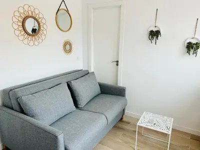 a living room with a couch and a mirror at Vilamarlux VII in Vilassar de Mar