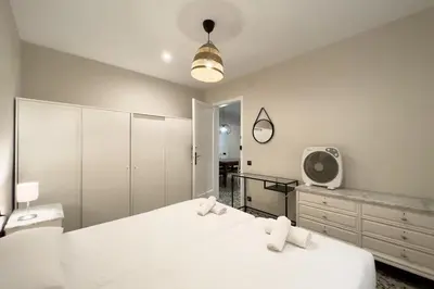 a bedroom with two white beds and a mirror at BeBarceloner Eixample Apartments - 3 bedrooms in Barcelona