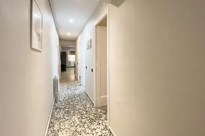 a hallway with a mirror and a white hallway at BeBarceloner Eixample Apartments - 3 bedrooms in Barcelona