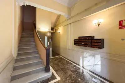 a hallway with a staircase in a building at BeBarceloner Eixample Apartments - 3 bedrooms in Barcelona