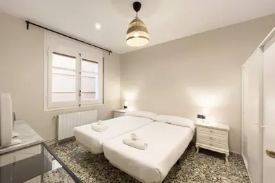 a white bedroom with a large bed and a window at BeBarceloner Eixample Apartments - 3 bedrooms in Barcelona