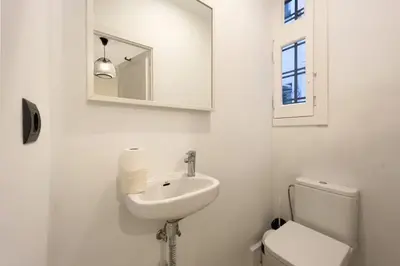 a white bathroom with a sink and a toilet at BeBarceloner Eixample Apartments - 3 bedrooms in Barcelona