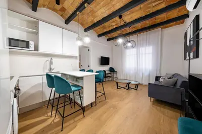 a bedroom with a white bed and a chair at BeBarceloner Eixample Apartments - 4 bedrooms in Barcelona
