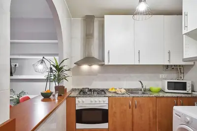 a kitchen with white cabinets and a stove top oven at BeBarceloner Eixample Apartments - 2 bedrooms in Barcelona