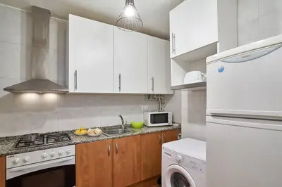 a kitchen with white cabinets and a stove top oven at BeBarceloner Eixample Apartments - 2 bedrooms in Barcelona