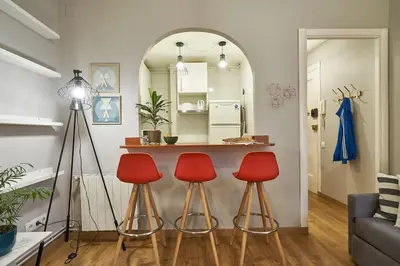 a living room with two red stools and a table at BeBarceloner Eixample Apartments - 2 bedrooms in Barcelona