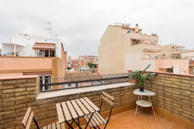 a balcony with two chairs and a bench on a building at BeBarceloner Sant Andreu Apartments - Attic with terrace in Barcelona