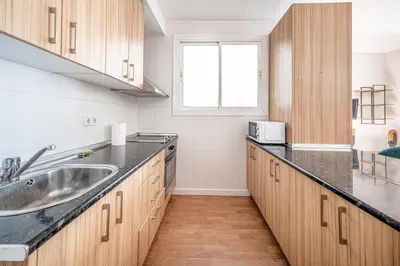 a kitchen with wooden cabinets and a sink at BeBarceloner Sant Andreu Apartments - 1 bedroom with terrace in Barcelona
