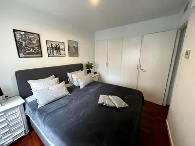 a bedroom with a large black bed with pillows at Pure Bliss Apartment Sitges in Sitges