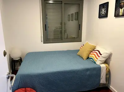 a bedroom with a blue bed with a window at Pure Bliss Apartment Sitges in Sitges