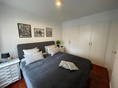 a bedroom with a large bed and white cabinets at Pure Bliss Apartment Sitges in Sitges