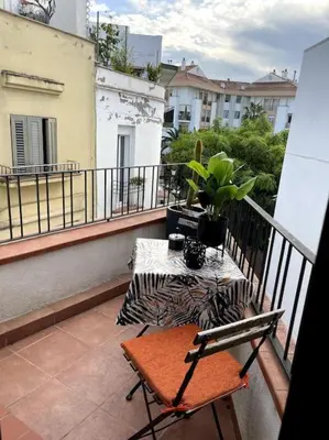 a balcony with a bench and a table on a balcony at Pure Bliss Apartment Sitges in Sitges