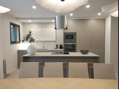 a kitchen with a table and chairs and a vase at Sitges Spaces Bonaire Beach Condo in Sitges