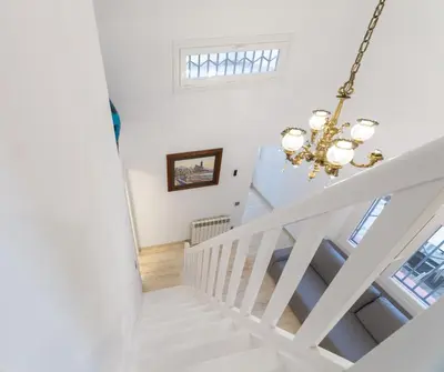 a white staircase in a home with a chandelier at SILOM HOUSE in Sant Pere de Ribes