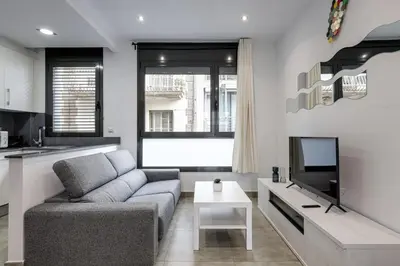 a living room with a couch and a tv at Urban Flats Vallirana in Barcelona