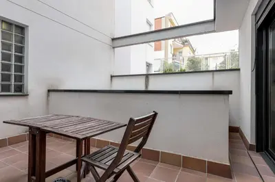 a wooden table and a chair on a balcony at Urban Flats Vallirana in Barcelona
