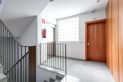 a hallway with a staircase and a wooden door at Urban Flats Vallirana in Barcelona