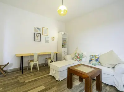 a living room with a white couch and a table at Casa Mediterránea en Badalona in Badalona
