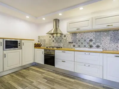 a kitchen with white cabinets and a stove top oven at Casa Mediterránea en Badalona in Badalona