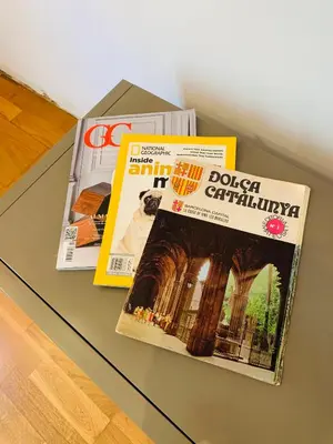 two magazines sitting on a glass table at Hermoso piso en el centro de Barcelona in Barcelona