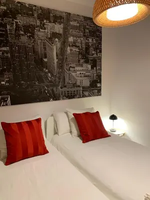 a bedroom with two beds with red and white pillows at Hermoso piso en el centro de Barcelona in Barcelona