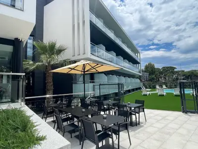 a patio with tables and chairs on a building at Hotel C31 in Castelldefels