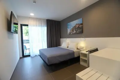 a hotel room with a bed and a window at Hotel C31 in Castelldefels