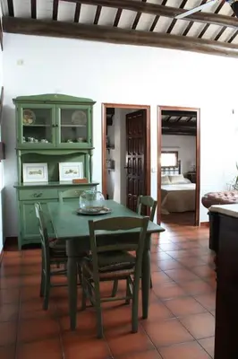 a dining room with a green table and chairs at Cal Negre 2 in Vilassar de Mar